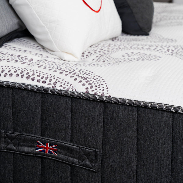 Spink & Co Padworth Firm mattress side detailing showcasing the carrying handle with Union Jack flag and mattress cover fabric.