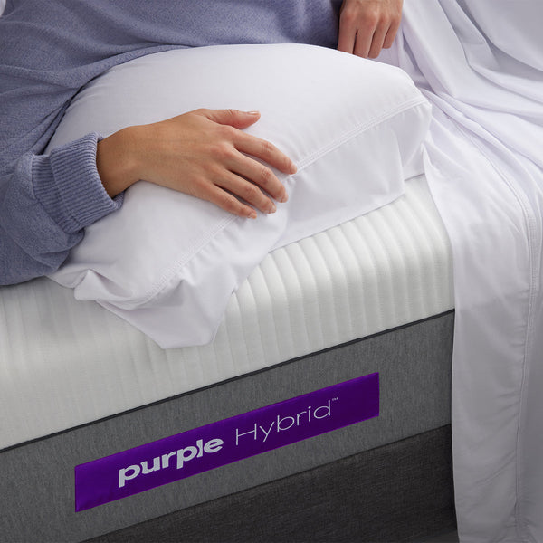 Woman Relaxing With Pillow On The Purple Hybrid Mattress