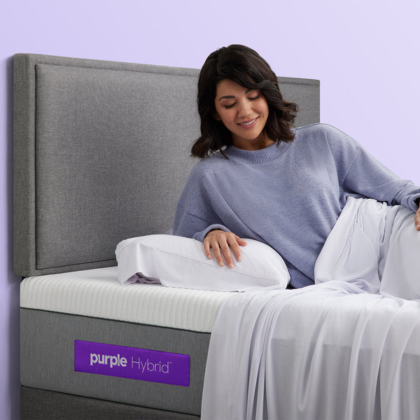 Woman Relaxing With Pillow On The Purple Hybrid Mattress