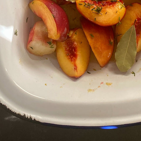 Cooked peaches in a baking tin.