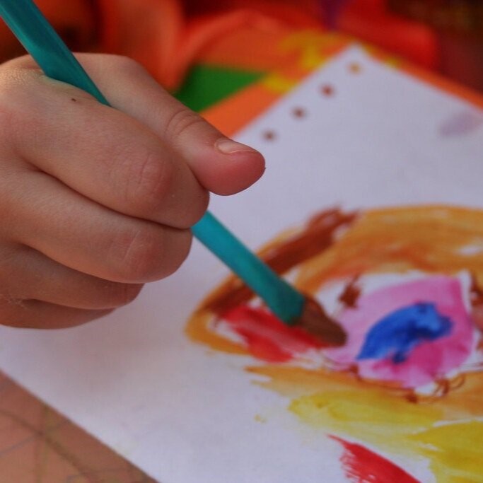 Image of a child painting, photo by Noj Han