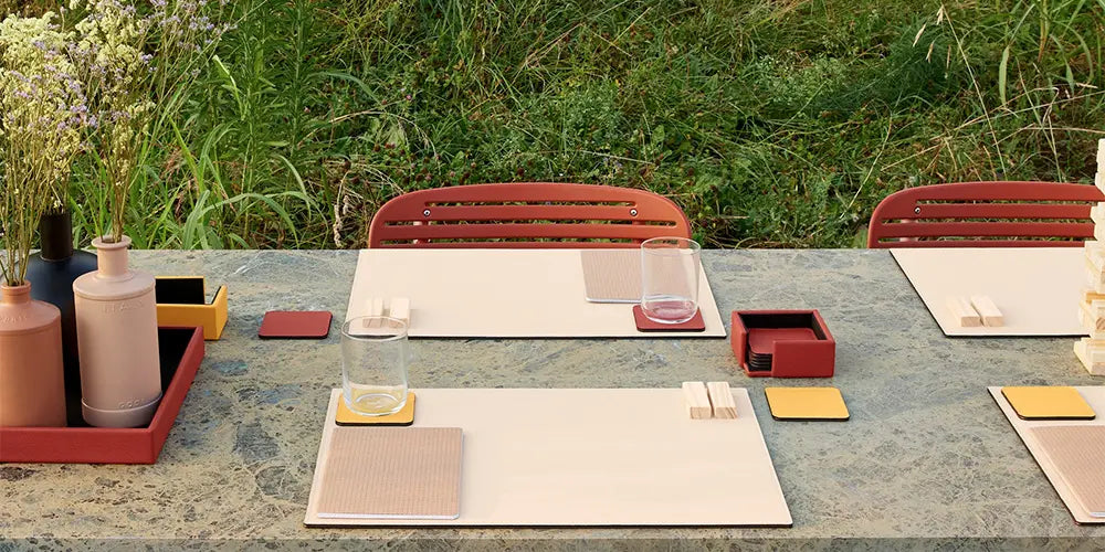 Leather Desk Accessories for Versatile Spaces: Elegance Anywhere Marble table with leather desk accessories: placemats, coasters, and note holder in an outdoor setting
