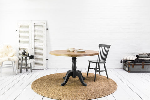 Round oak dining table with pedestal base.