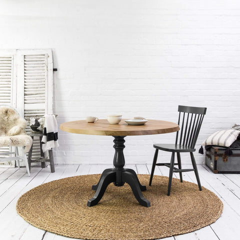 A Kiki rustic oak round table with a chair.