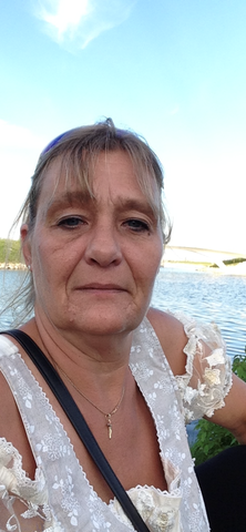 Belinda smiling in front of a lake.