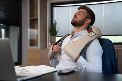 man using neck masasger with heat to relax muscles