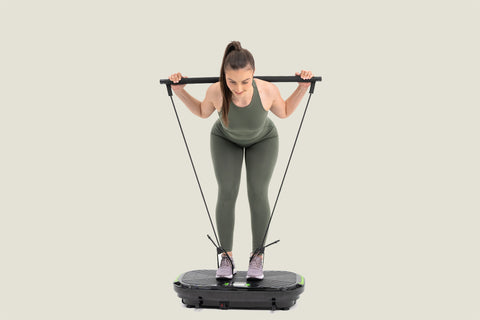 woman doing exercise for upper back using resistance bands on vibro plate