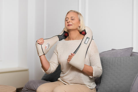 woman enjoying soothing masasge with electric neck masasger in comfort of home