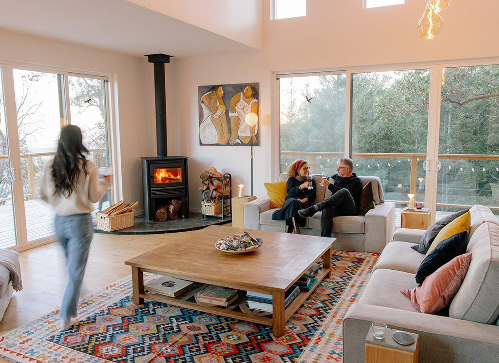 Three people sitting in their open plan living room