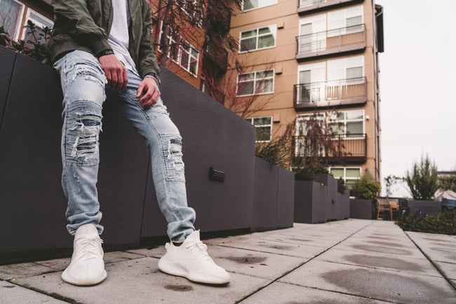 man wearing distressed acid washed jeans