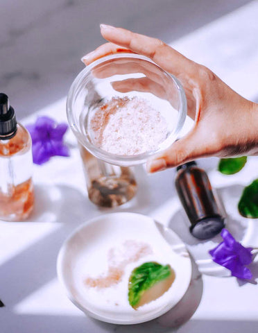 Hand holding powder in glass bowl