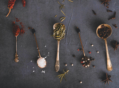 Image of various spoons with spices on them.