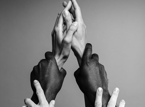 Three sets of hands holding each other by the wrist