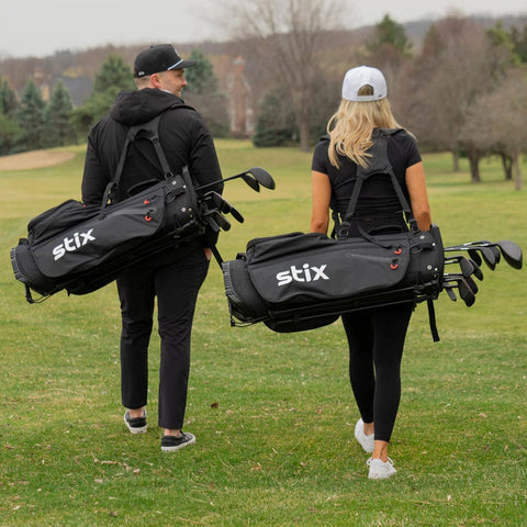 Male/ Female golfers carrying STIX golf club bags walking the course.