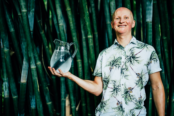 Founder Igor Pershin holding a water jug with bamboo charcoal water filter inside.