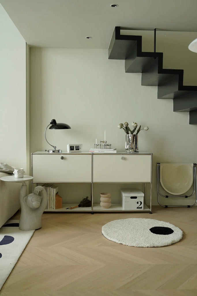 Modern interior with a staircase, white inspired recreation USM modular console side table, and decorative items.