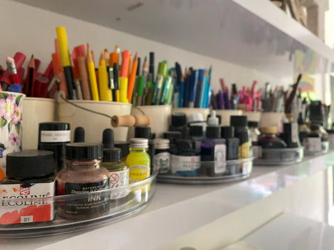 A shelf holding lots of bottles of ink