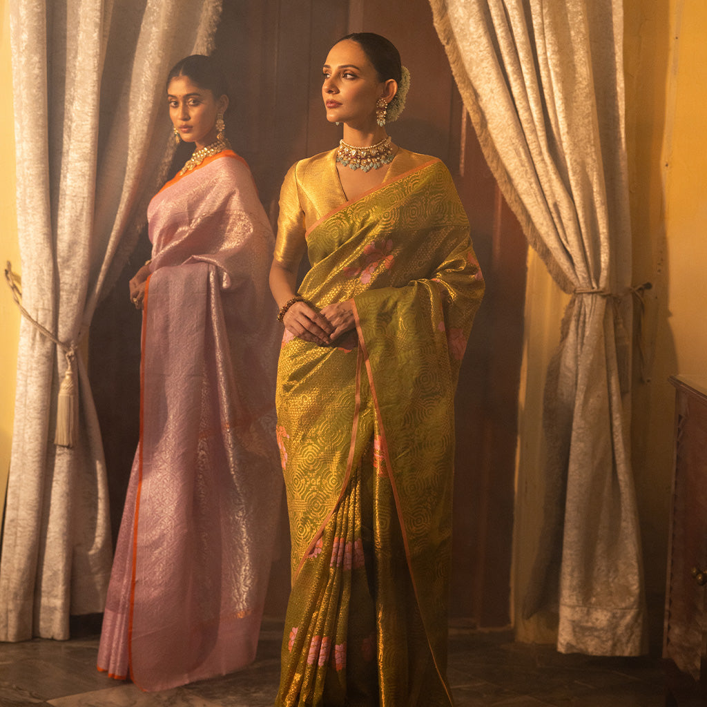 Two woman wearing SónChiraiya zari Kota handloom sarees facing each other.