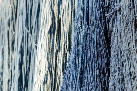 organic cotton yarn dyed with herbal dyes hangs from above