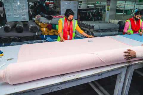 Bears for Humanity worker cuts fabric in a Fair Trade facility