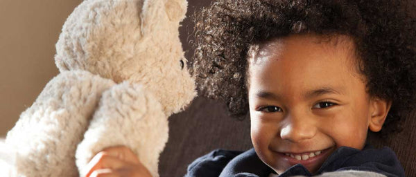 Small boy plays with Fair Trade and Organic Teddy Bear