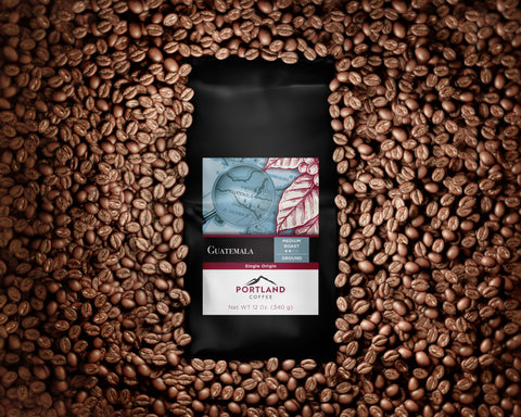 Image of a 12oz bag of Guatemala Medium Roast on a pile of coffee beans