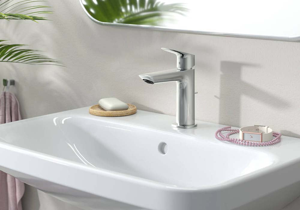 Wall-mounted bathroom sink with chrome faucet and soap holder.