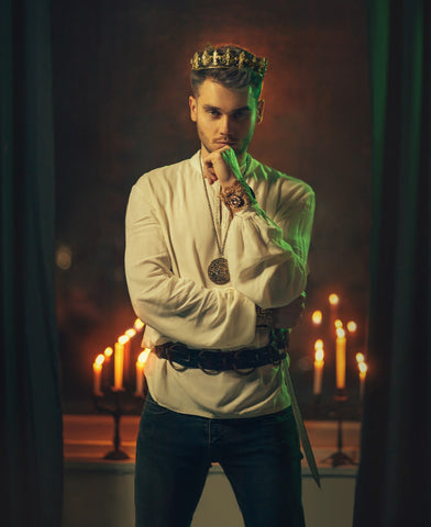 Handsome young man in crown staring thoughtfully