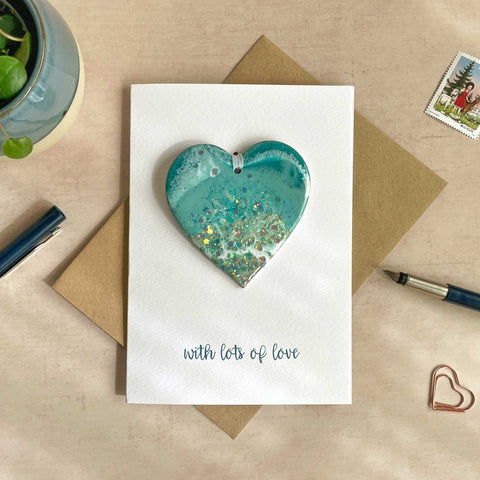 swiss lake inspired hanging heart decoration on a card which reads "with lots of love"