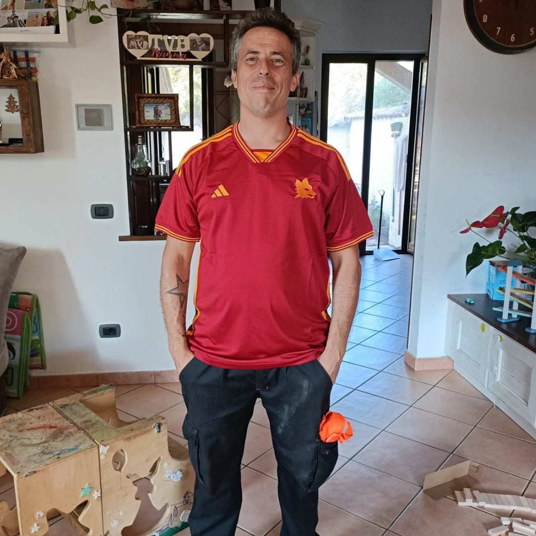 Person in a red sports jersey standing in a living room.