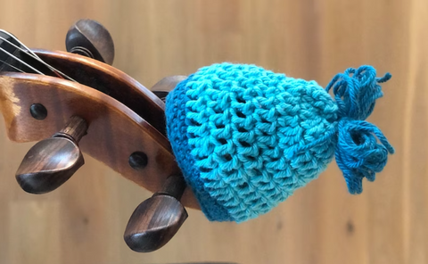 A blue crocheted violin scroll hat