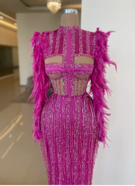 A pink dress with feathers on a doll