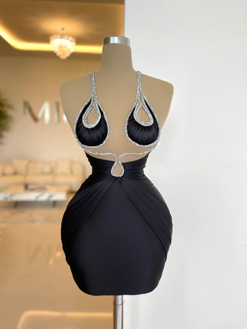A short black dress with crystals on a doll