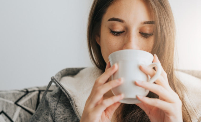 Woman Sipping From Cup With Mushroom Supplement