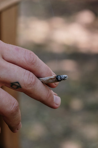 Une personne tenant un joint de marijuana