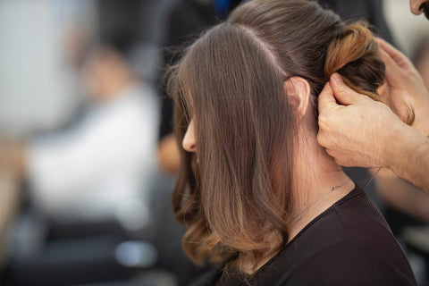Une femme qui se fait coiffer dans un salon de coiffure