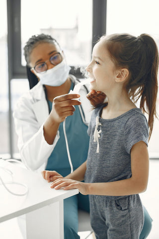 Un médecin donnant un inhalateur à un enfant