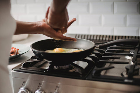 A person cooking eggs in their kitchen