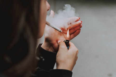 A woman lighting up a cigarette