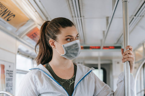 Une femme portant un masque à bord d’un bus