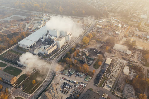 A bird's eye view of a factory emitting polluted air