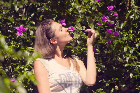 Une femme sentant une fleur