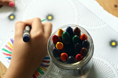 Un enfant qui dessine avec des crayons en papier à l'école