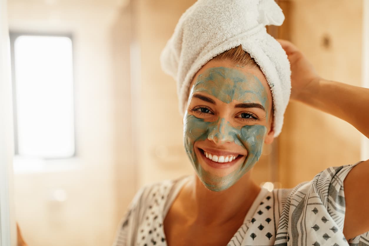 woman smiling with face scrub