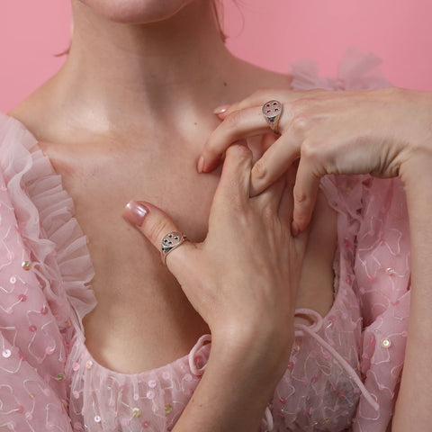Woman in pink dress wearing UNE Jewellery Asteria Rings