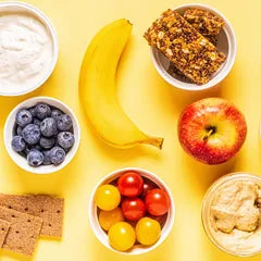 Toddler snacks, yoghurt, blueberries, tomatoes, peanut butter, muesli bars, apple, banana, and crackers