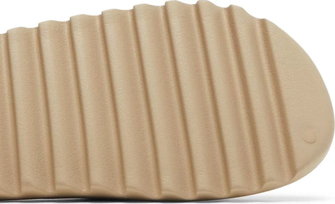 The Adidas Yeezy Slide “Pure 2021” is the December 2021 release of Kanye West’s earth-tone slip-on sandal. Brought back by Adidas for a second time in 2021, the first release being in April 2021, the “Pure” features a beige-colored lightweight EVA foam construction for maximum comfort whether traversing through the city streets or relaxing poolside. The midfoot arch stabilizes the foot and the ridged outsole provides grip on slippery surfaces.