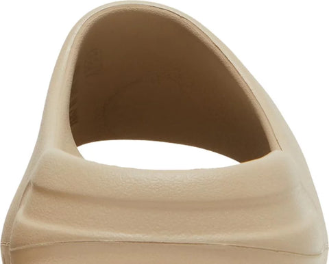 The Adidas Yeezy Slide “Pure 2021” is the December 2021 release of Kanye West’s earth-tone slip-on sandal. Brought back by Adidas for a second time in 2021, the first release being in April 2021, the “Pure” features a beige-colored lightweight EVA foam construction for maximum comfort whether traversing through the city streets or relaxing poolside. The midfoot arch stabilizes the foot and the ridged outsole provides grip on slippery surfaces.