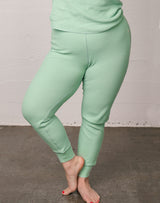 Woman wearing waffle thermal pajamas in sage.