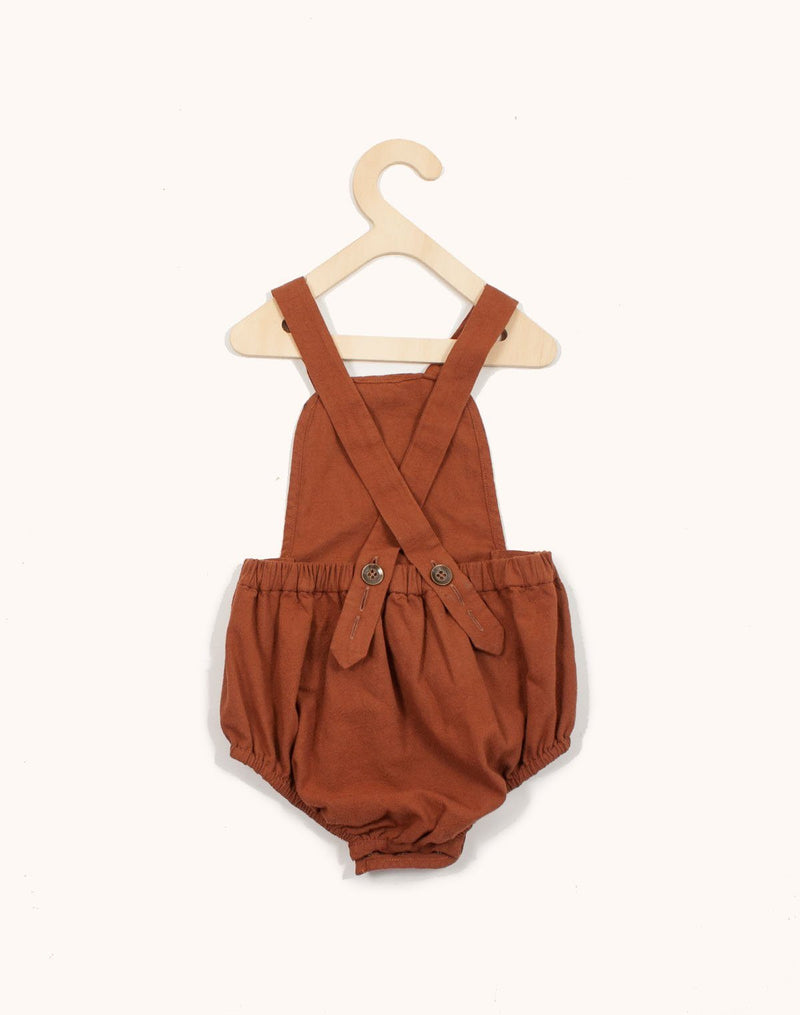 Back of the Noble Sun Suit in Cinnamon color hanging from a kids hangar